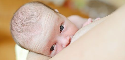 Newborn baby beeing breast fed