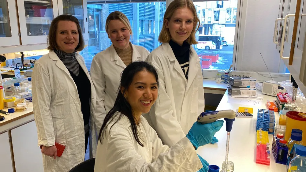 Fire kvinner på lab med labfrakk