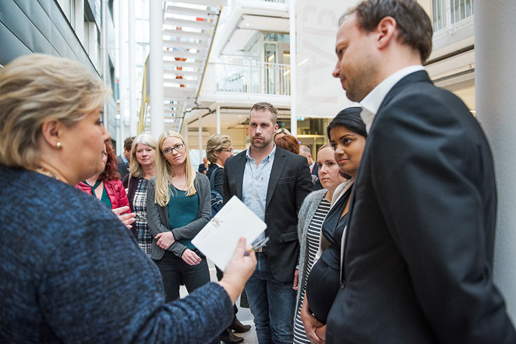 The picture shows Prime Minister Erna Solberg talking with PhD candidates and postdoctoral researchers from the faculty of medicine.