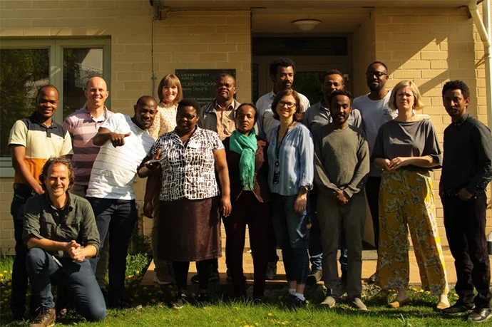 A group of researchers stadning together, smiling