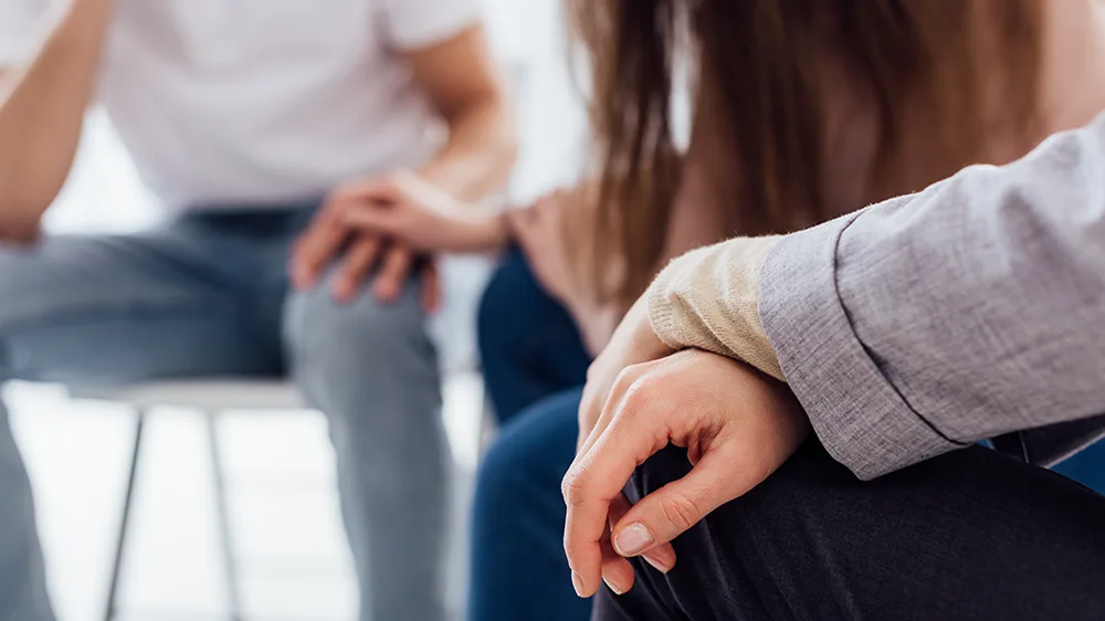 Family members holding a patient's hand in support