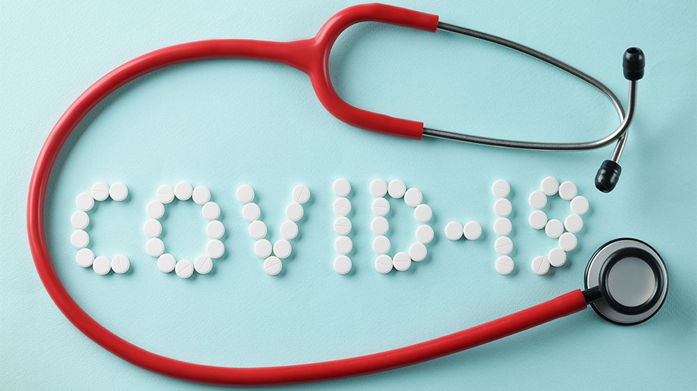 illustration: A red stethoscope on a pale blue background. Covid-19 written in white letters