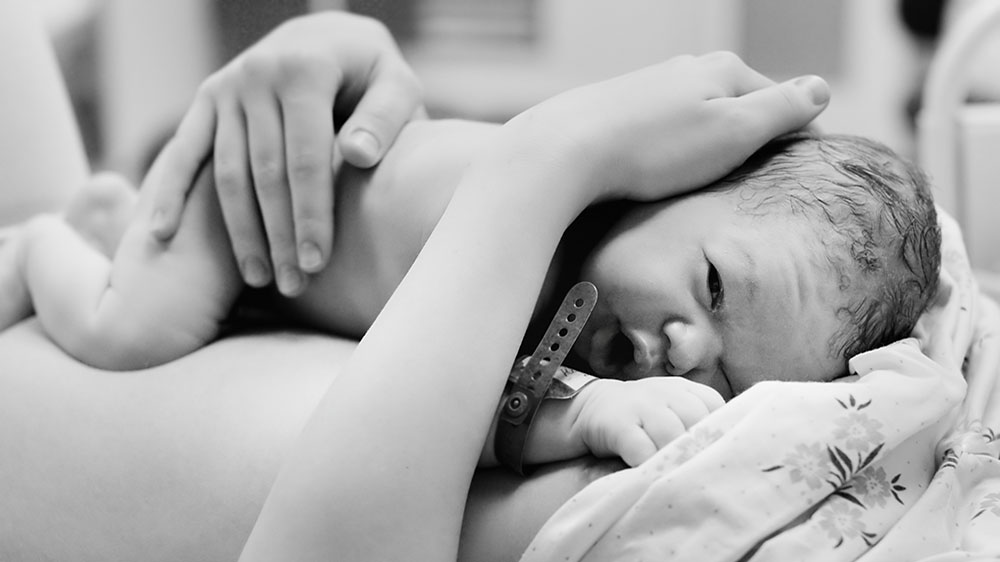 A mother hugging her newborn child