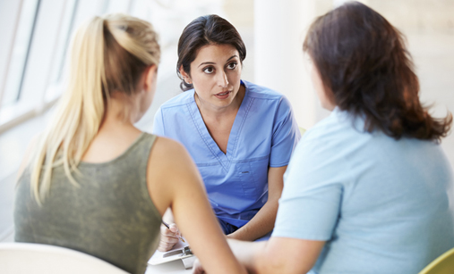 Nurse in conversation with patient and family