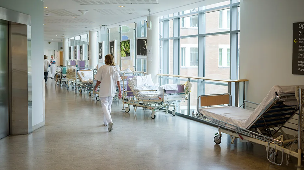 Sykepleier som går i gangen på et sykehus