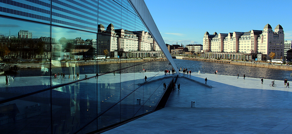Operataket i Oslo, byen speiler seg i refleksjonen fra operabygget. På høgre side av bilde er det lagt inn informasjon om EUHEA-konferansen: dato, tid og tema.