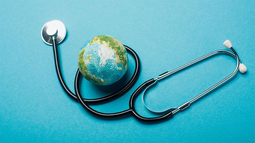 Illustration healthy planet - earth placed on a blue background with a stethoscope wrapped around it.
