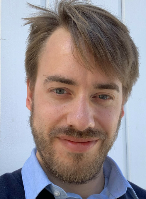 Profilbilde Solberg. Mann, brunt kort hår, forsiktig smil, blå genser med lyseblå skjorte under. 