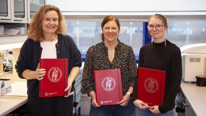 Image shows three women holding red prize diplomas