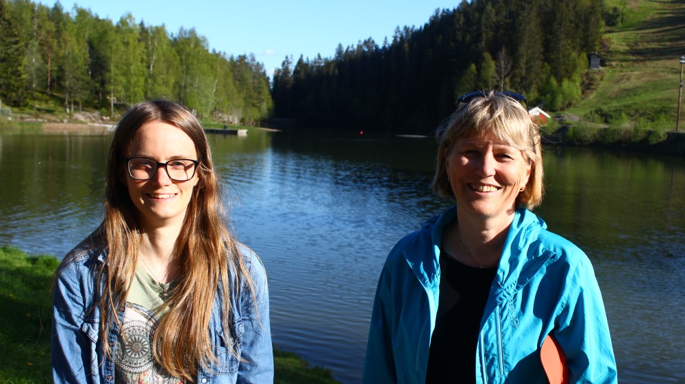 Picture shows two women in front of a lake