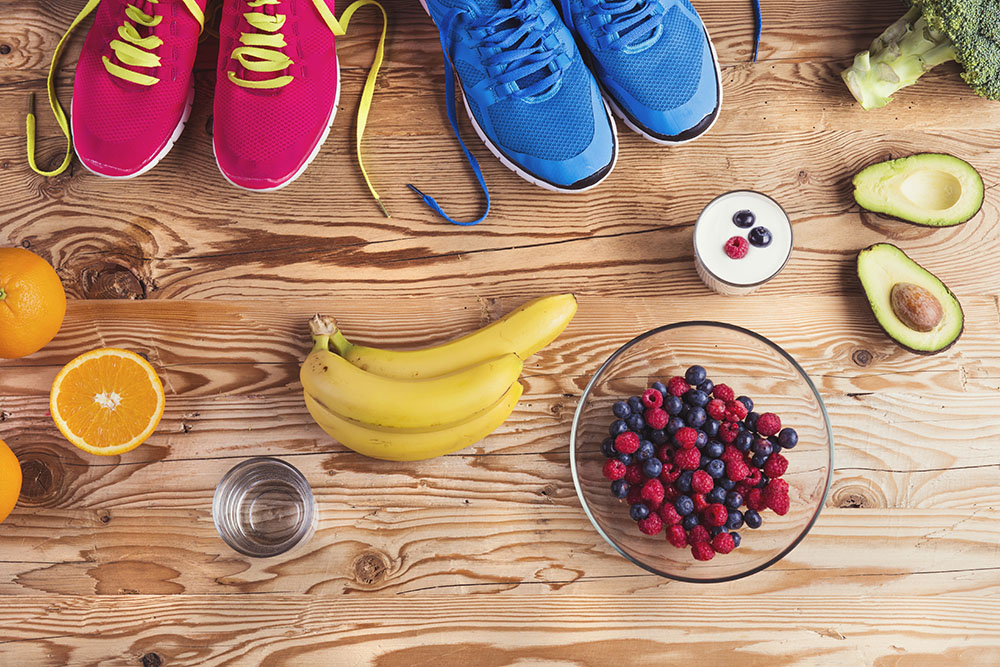 Colourfull running shoes, fruits and vegetables on a table