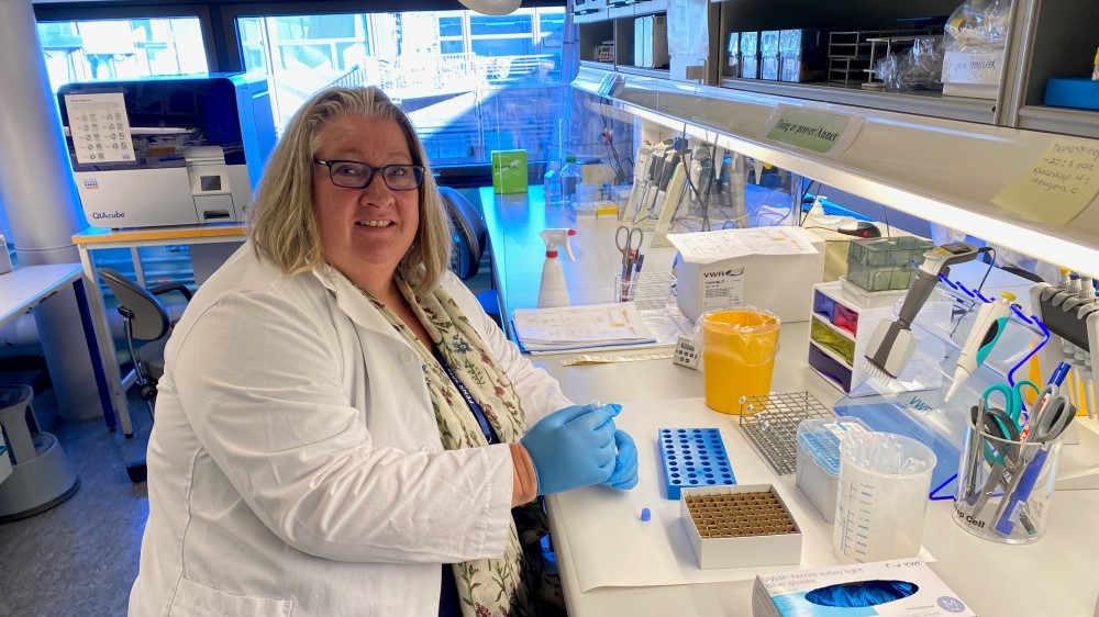 Bildet viser en kvinne i labfrakk inne på et laboratorium