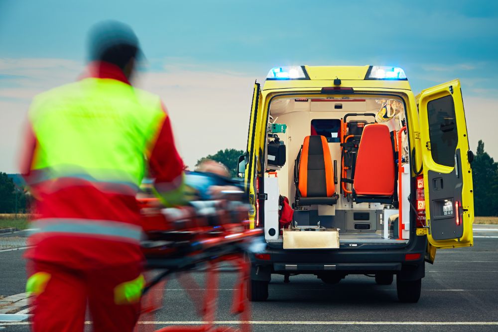 Bilde av ambulansearbeider og en ambulanse.