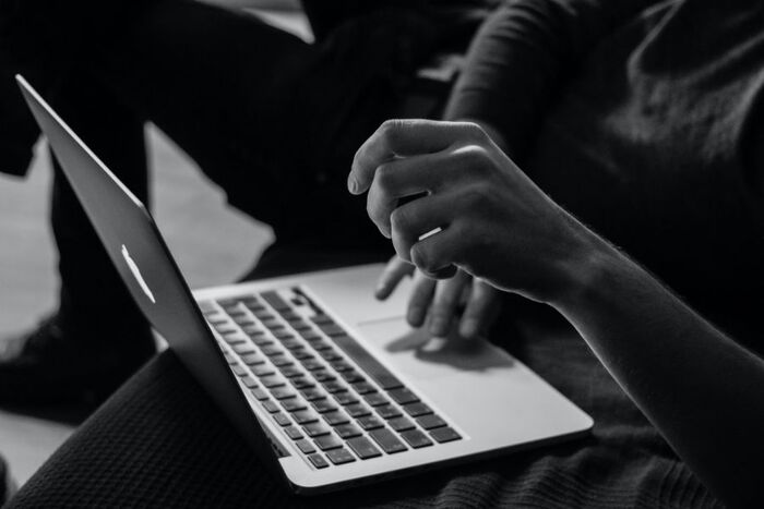 Person med laptop på fanget. Svart hvitt-foto