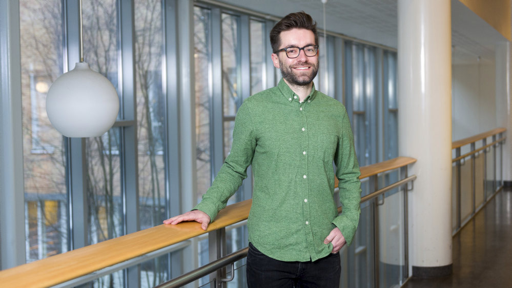 Bildet kan inneholde: briller, skulder, smil, kjole skjorte, synsomsorg.