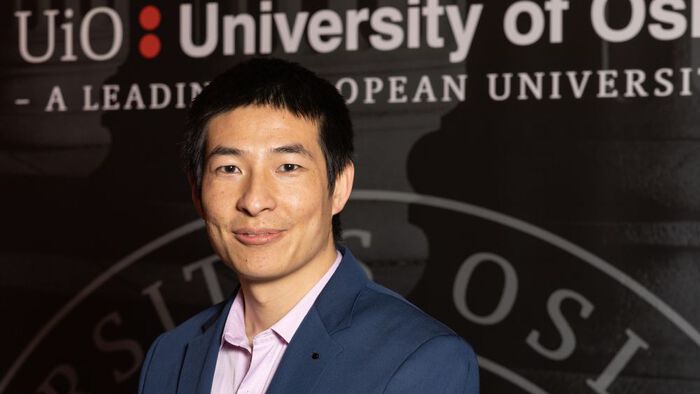 Bilde av Yanjiao Li foran en UiO-plakat