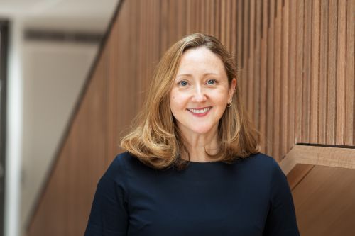 Portrait picture of Claire Booth in front of a wooden staircase banister.