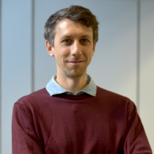 Profile picture of Adrien Peyrache wearing a burgundi jumper. The collar of his light blue shirt can be seen. The background of the picture is light grey.