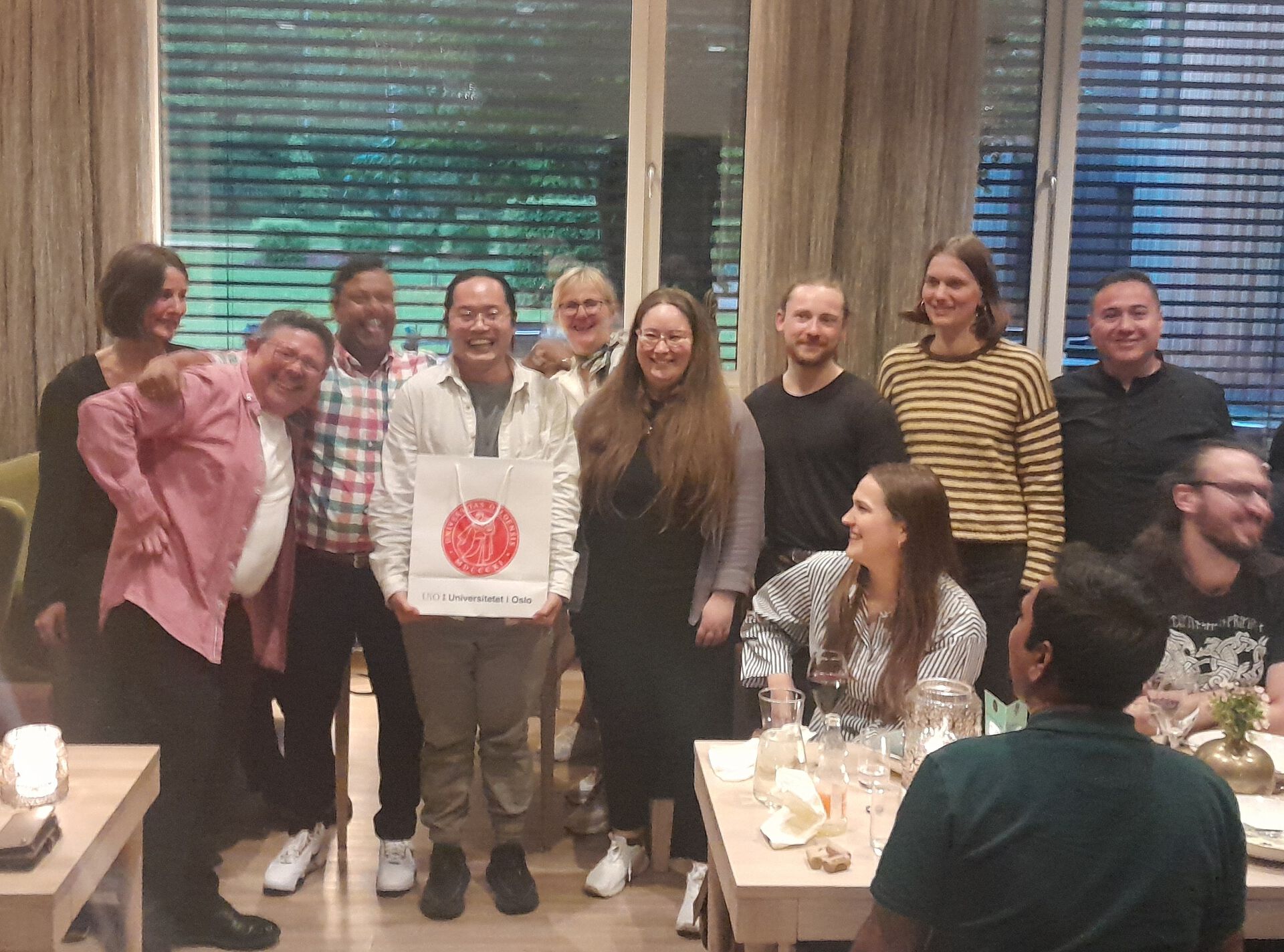 Group of people receiving their prize (in a UiO bag)-