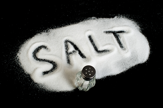 the word "salt" written in white salt on a black tabletop