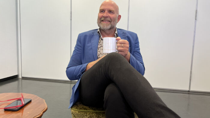 Helge Jordheim sits in front of a white wall